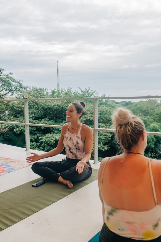 Hannah teaching a seated class on an open-air deck