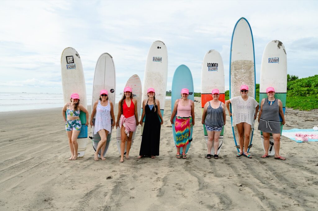 A group of women with surfboards on the beach
